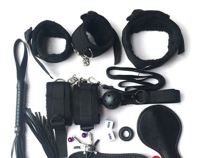 Collection of black restraining devices and accessories on a white background